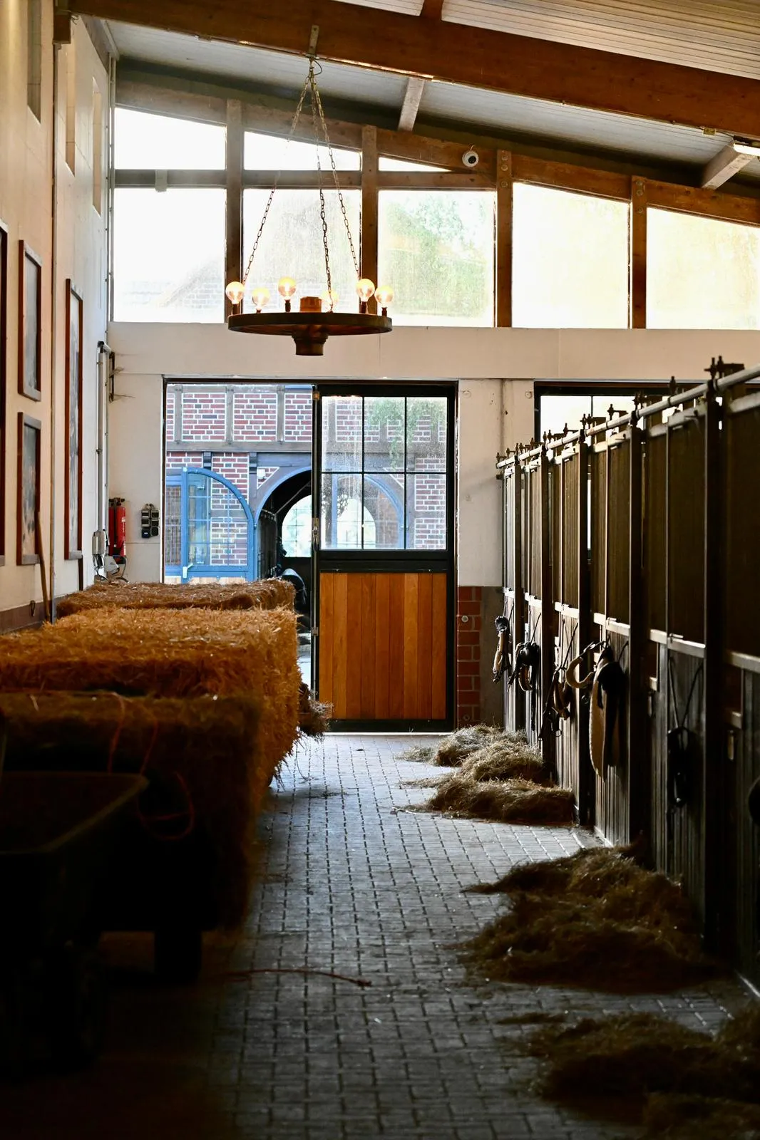 Stallgasse mit Pferdeboxen und Strohlager