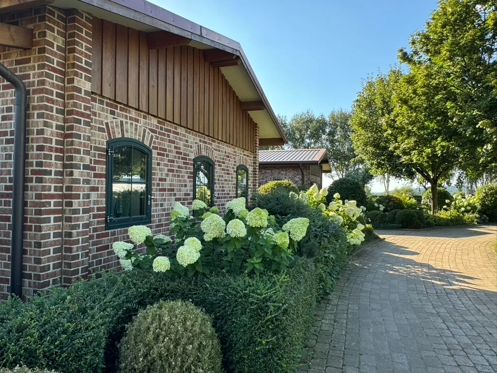 Hortensienbeete entlang der Stallgebäude